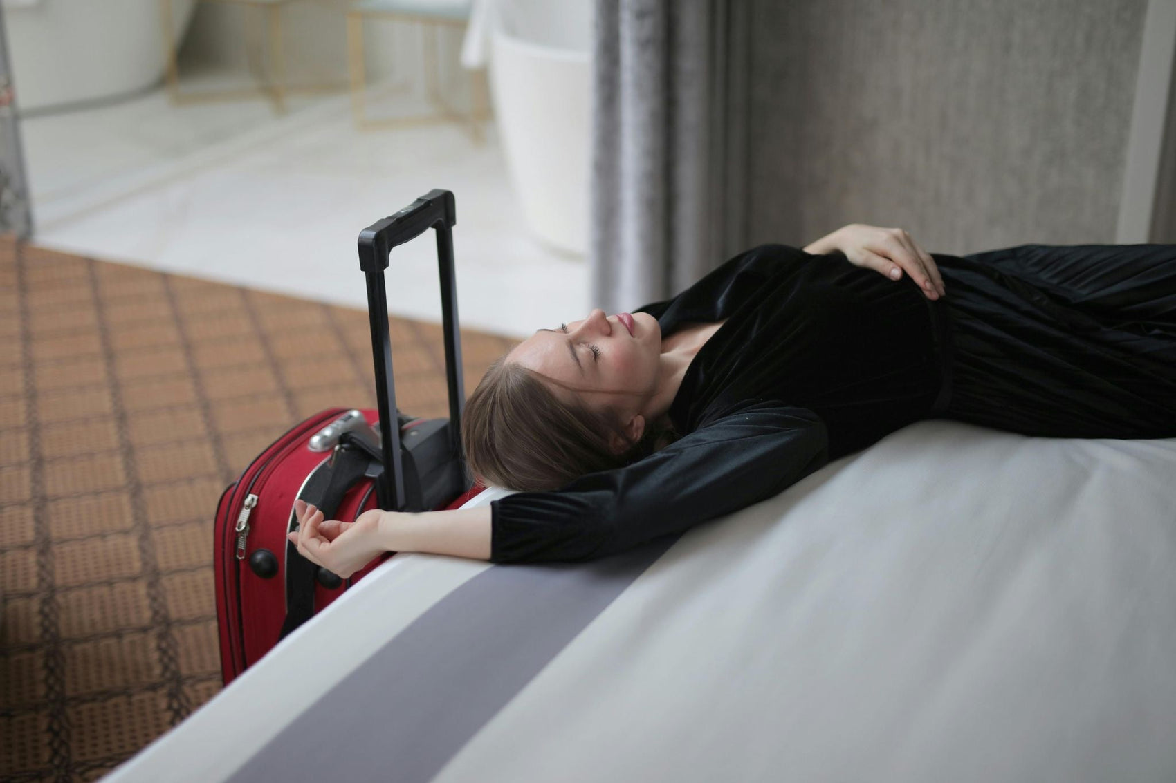 tired woman laying next to a luggage 
