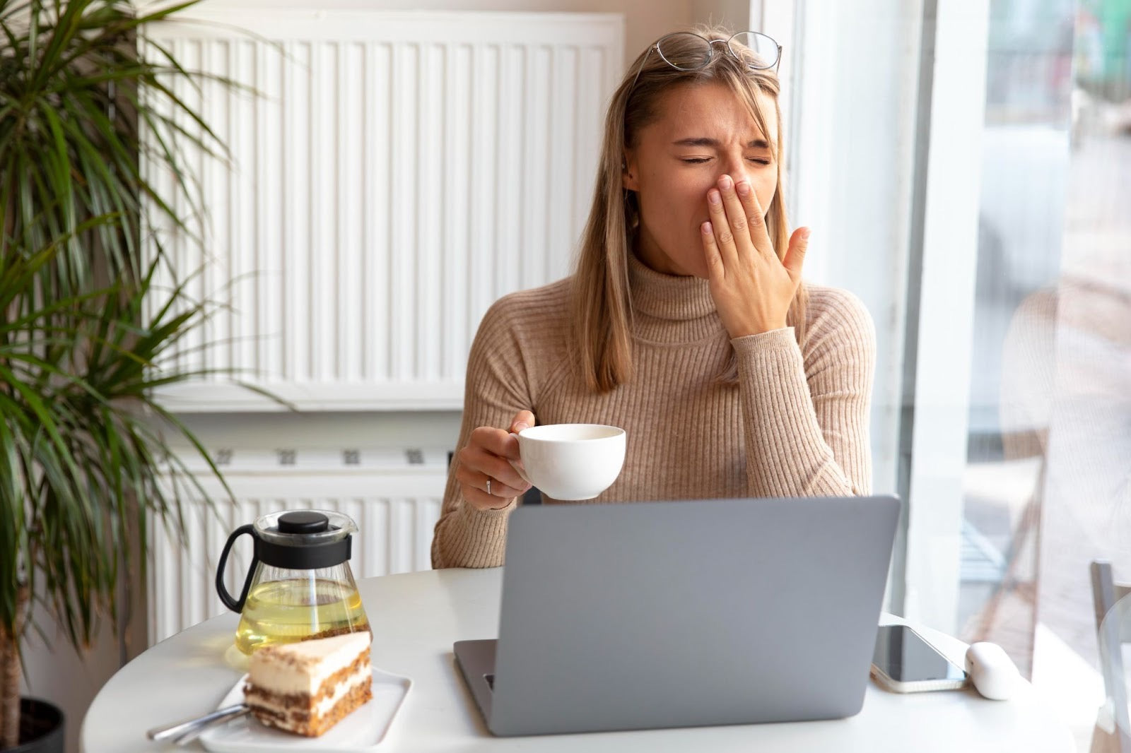 young woman yawning while working